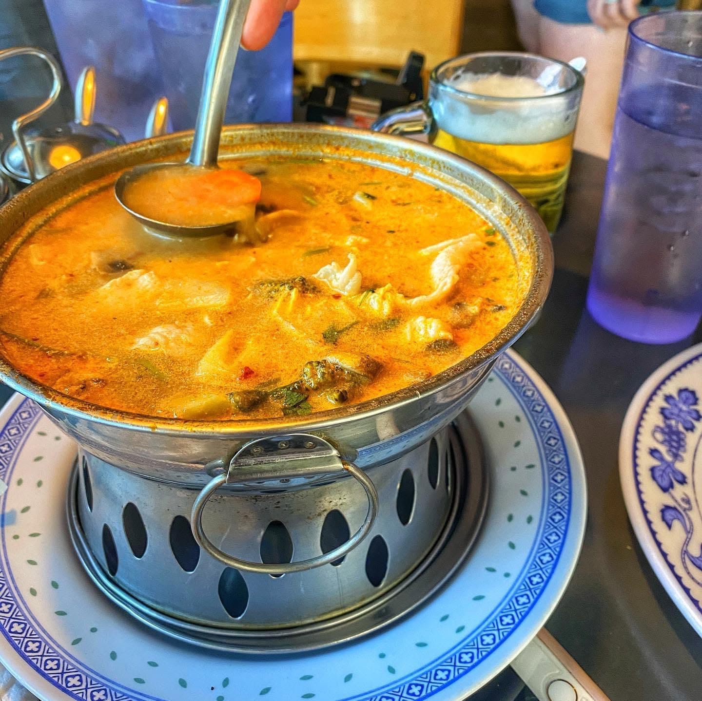 Thai garden curry in an ornate silver bowl with a ladle inside