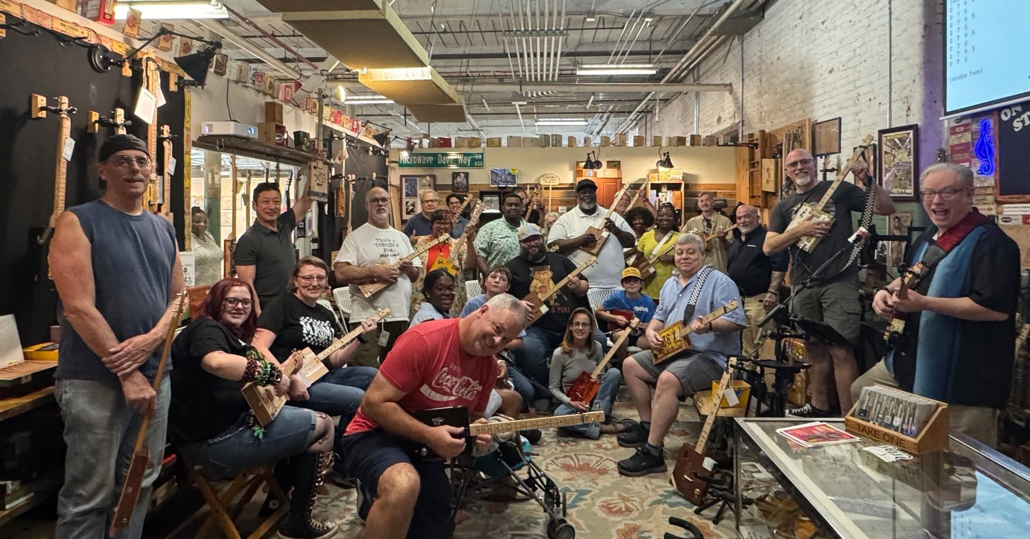 group taking class at cigar box guitar store